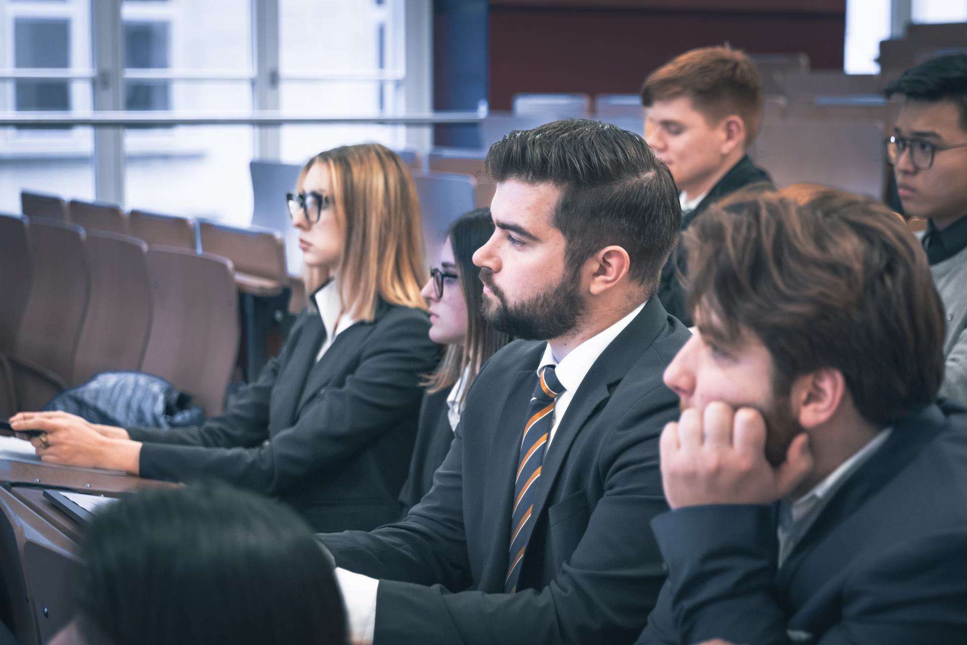 BHMS hotel management students in business dress attending a lecture in the auditorium